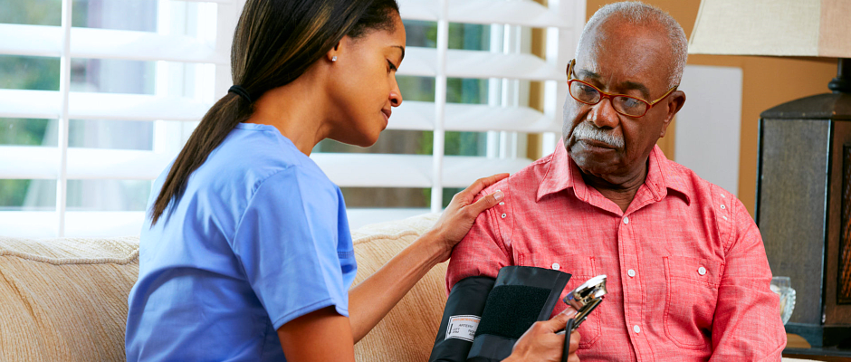 caregiver checking blood pressure to an elderly